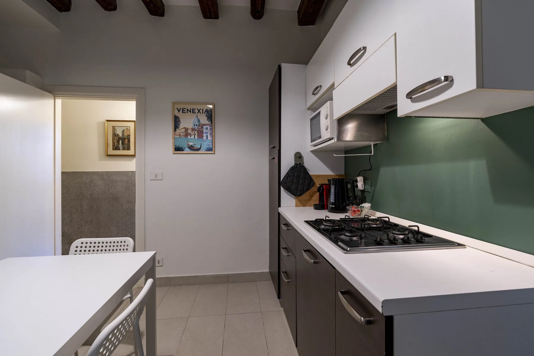Una cocina con una placa de cocción, una encimera y una mesa de comedor.