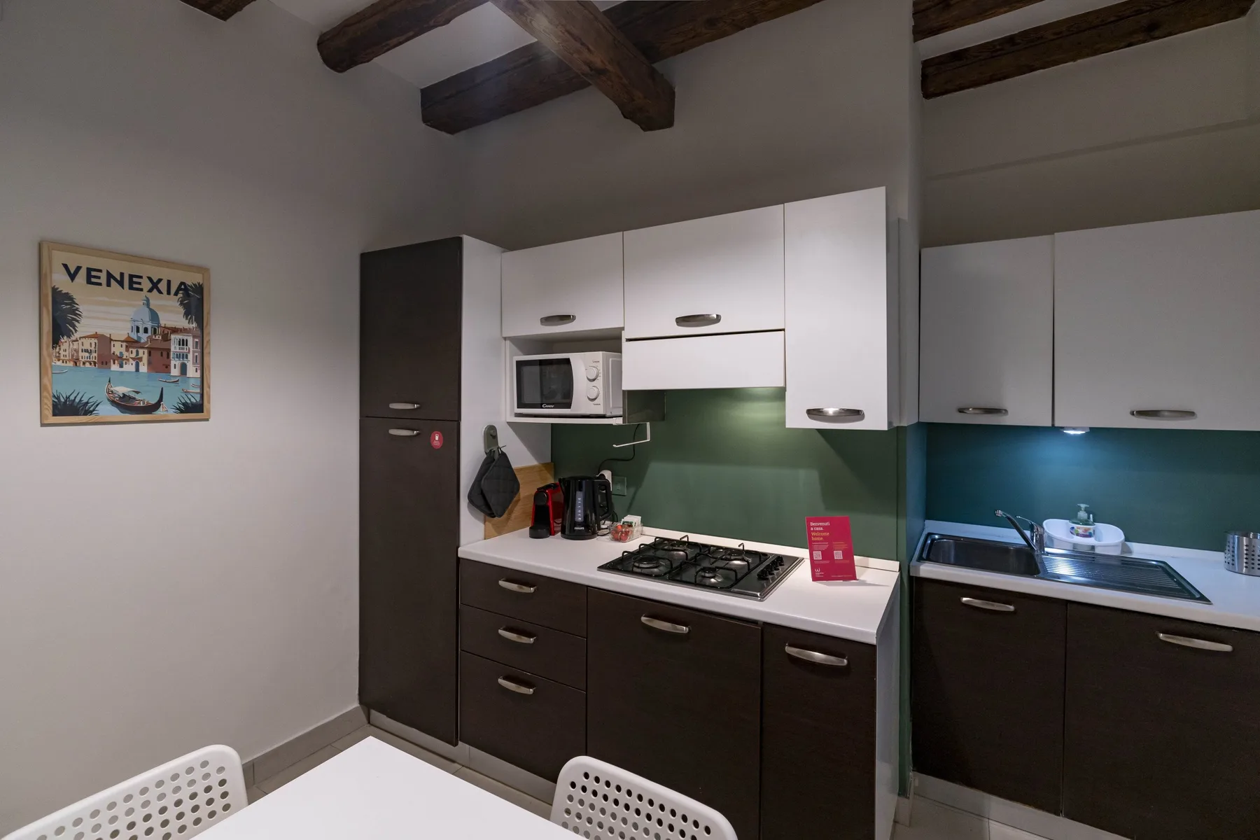 Una cocina compacta con gabinetes oscuros, armarios superiores blancos y una estufa.