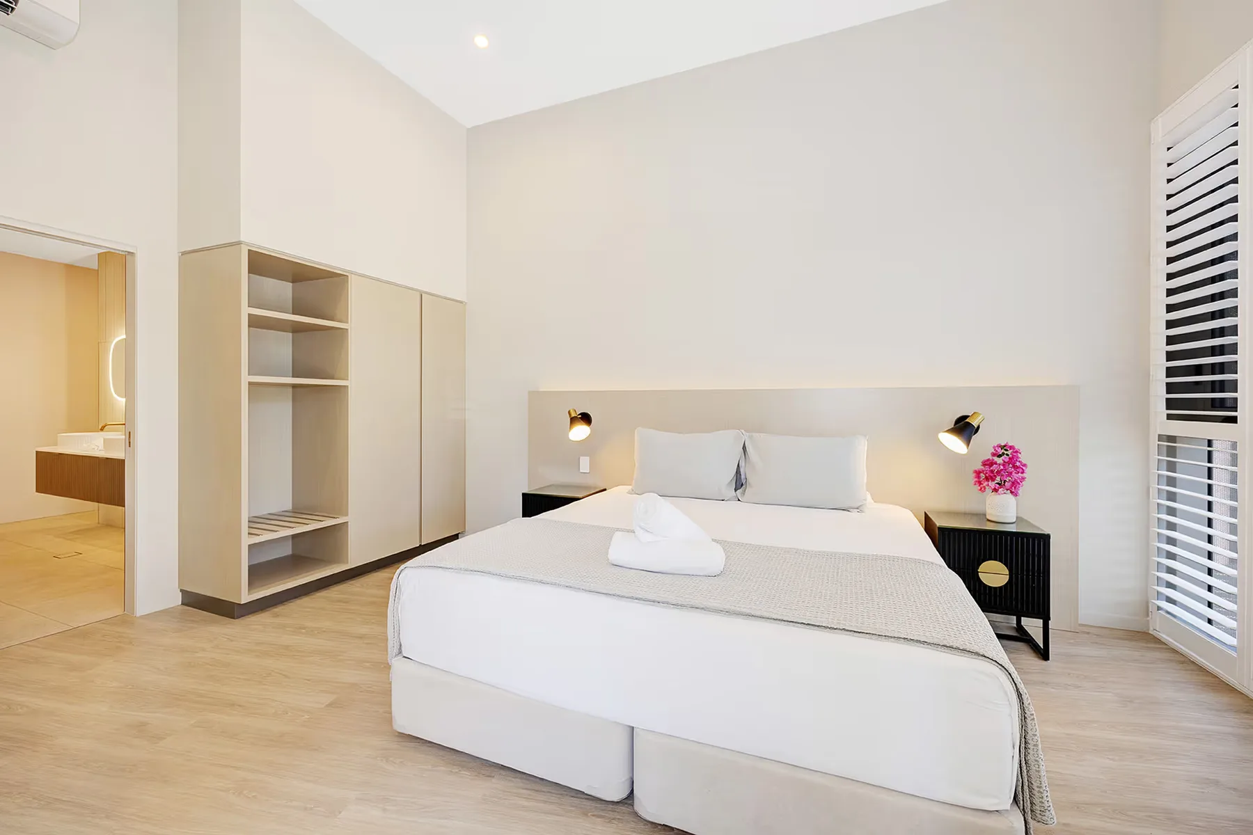 Dormitorio de la suite Executive con cama king y armario abierto.