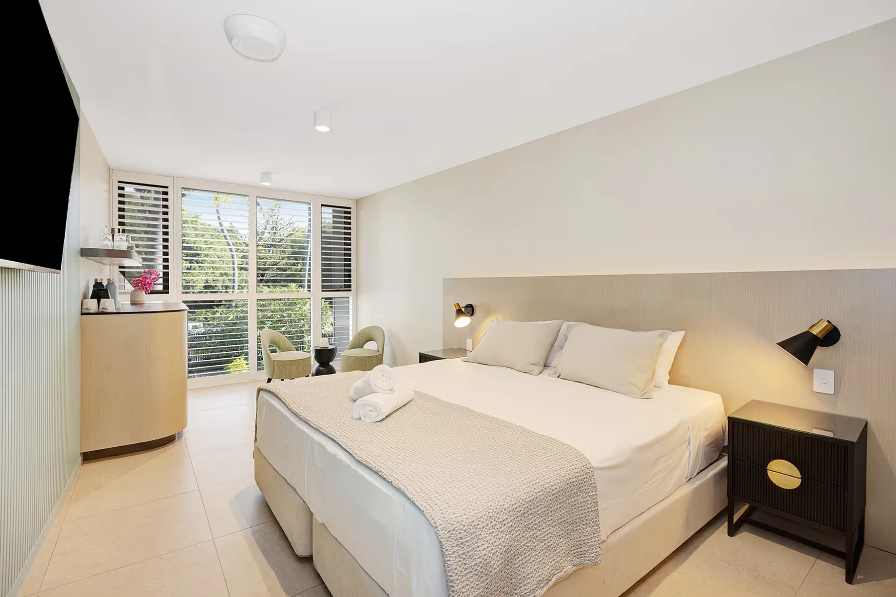 Habitación Garden View Superior con cama king y zona de estar junto a la ventana.