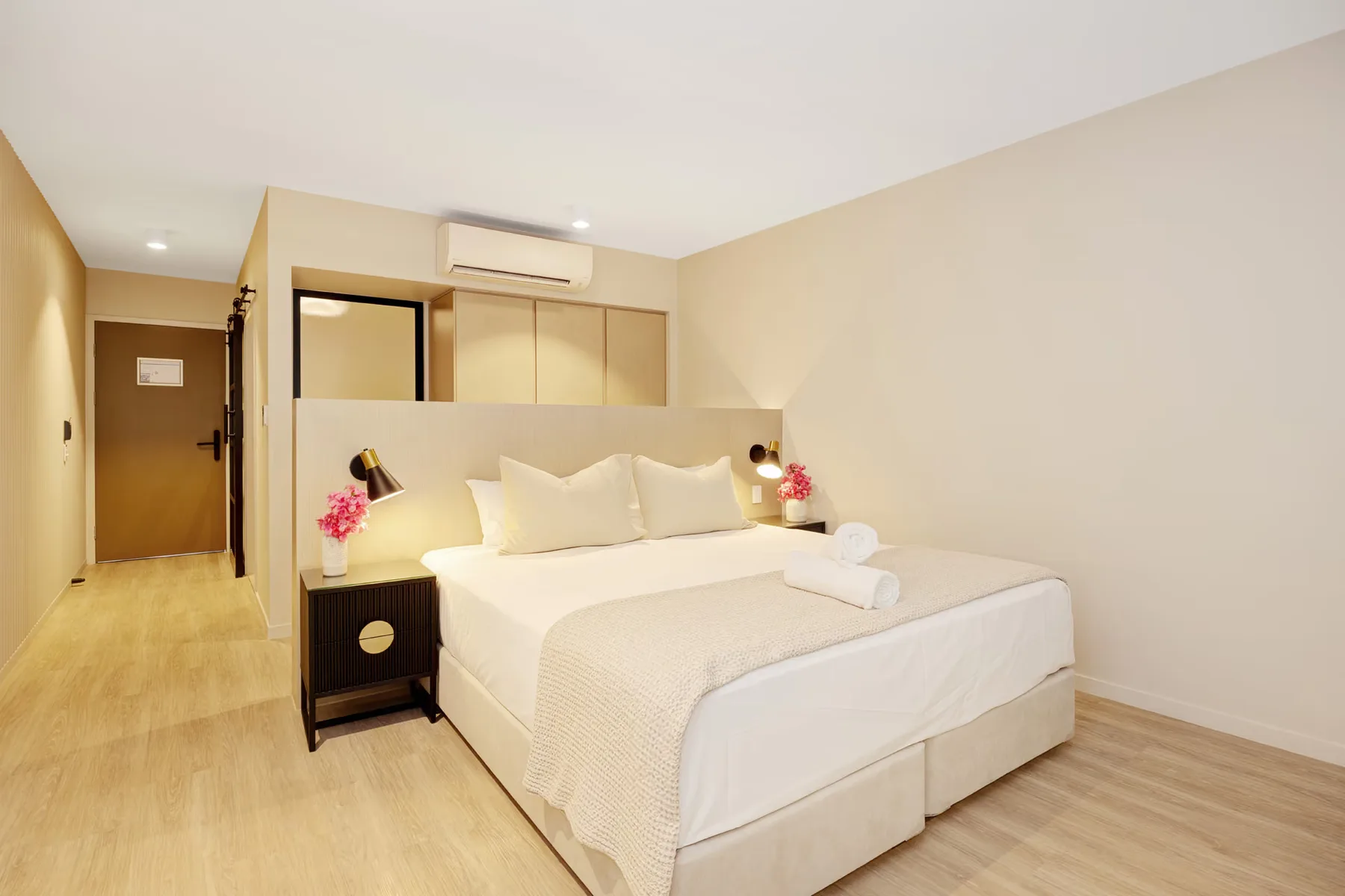 Habitación de huéspedes con cama king y mesitas de noche de madera.