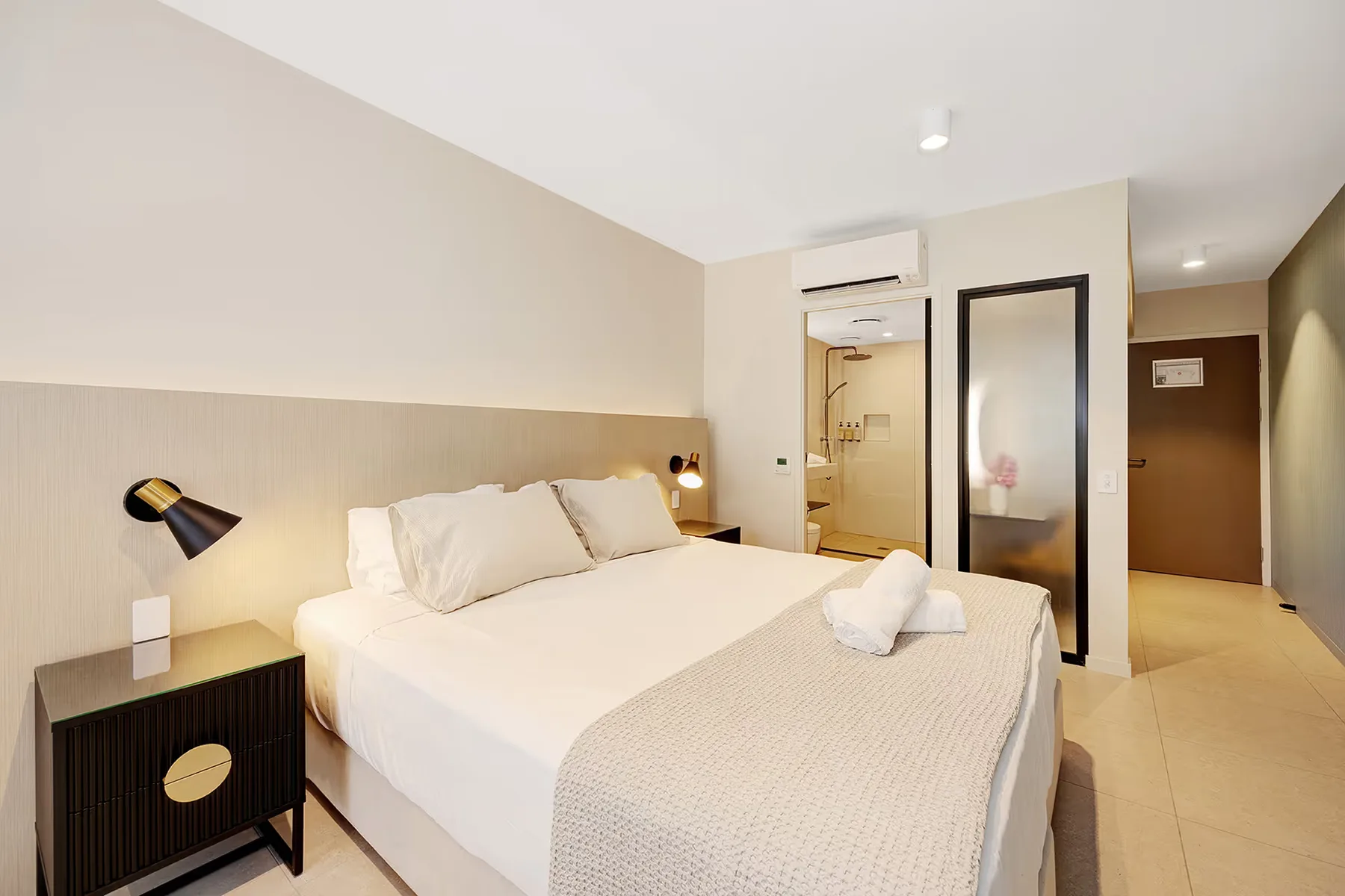 Cama king en la habitación Garden View Superior, con el baño privado al fondo.