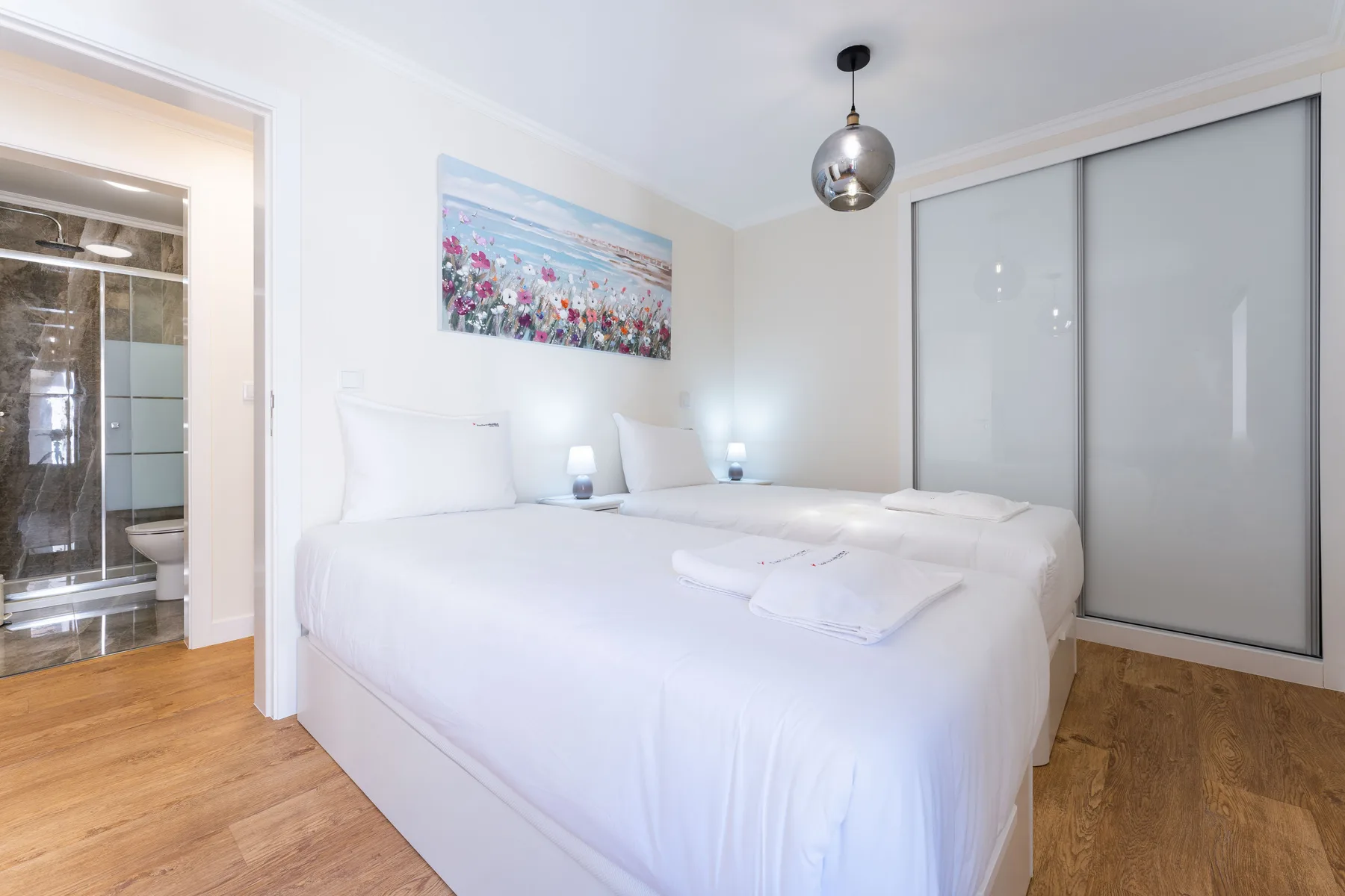 Un dormitorio luminoso con una cama grande y puertas correderas de armario.