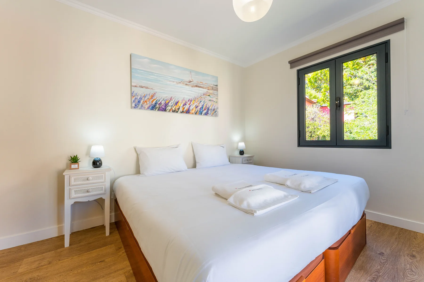 Dormitorio con una cama grande junto a una ventana.