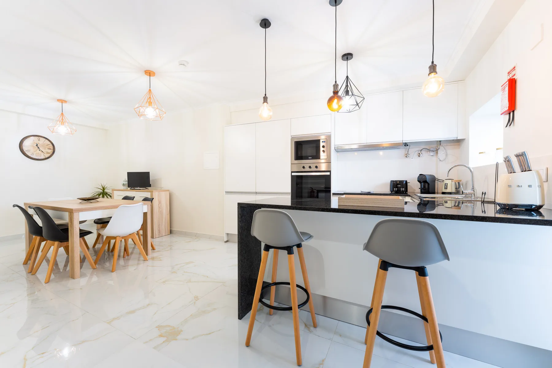 Una cocina luminosa con barra para desayunar y mesa de comedor.