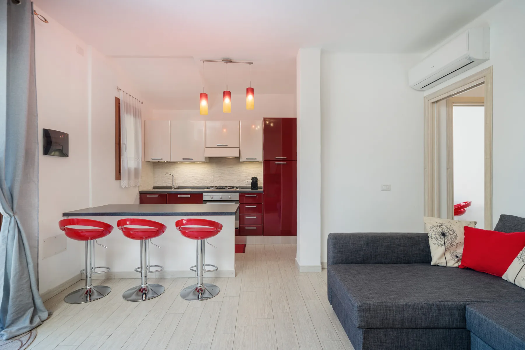 Una luminosa cocina abierta al salón, con barra para desayunar y asientos modulares.