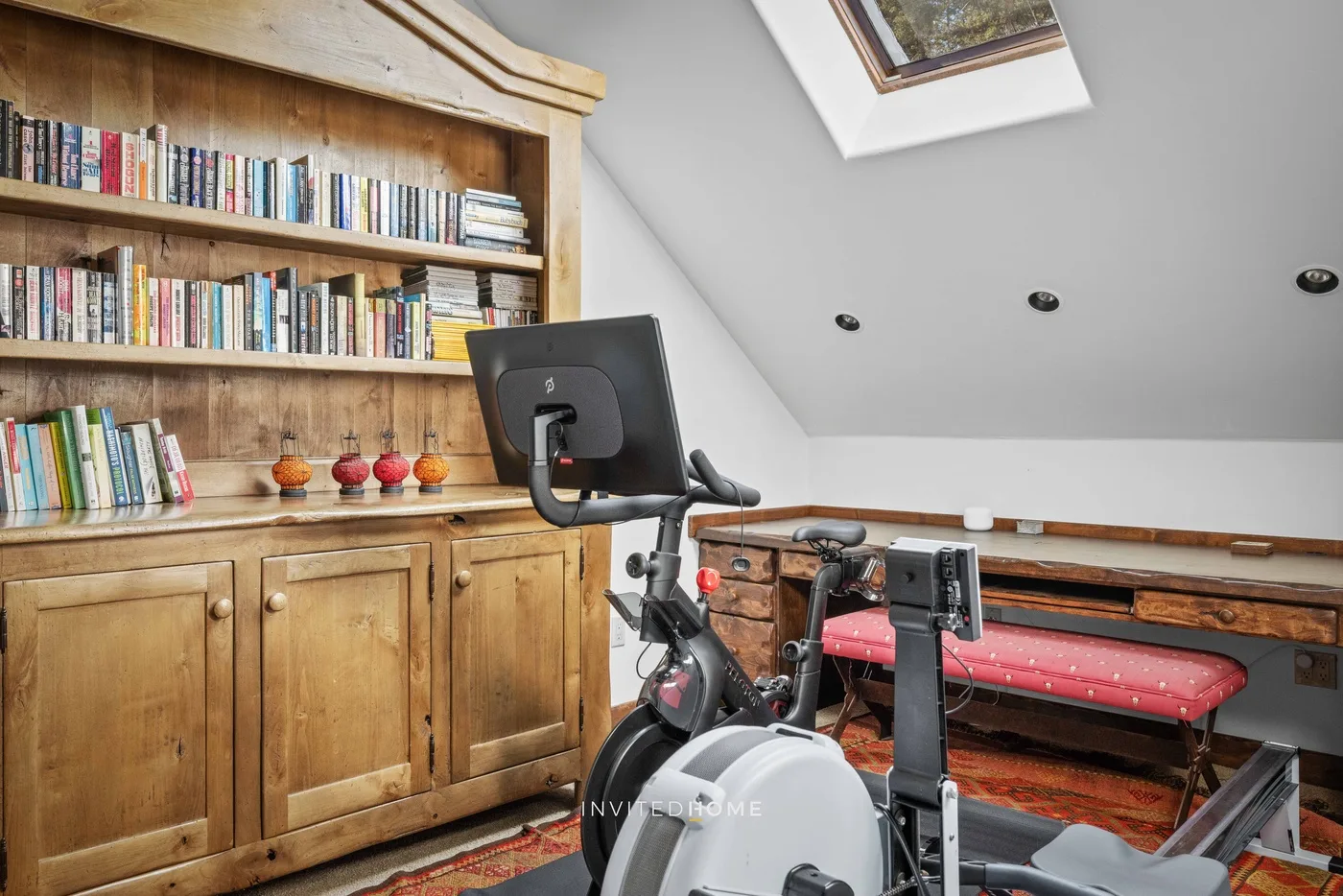 A home workout area with exercise equipment beside a wooden bookcase.