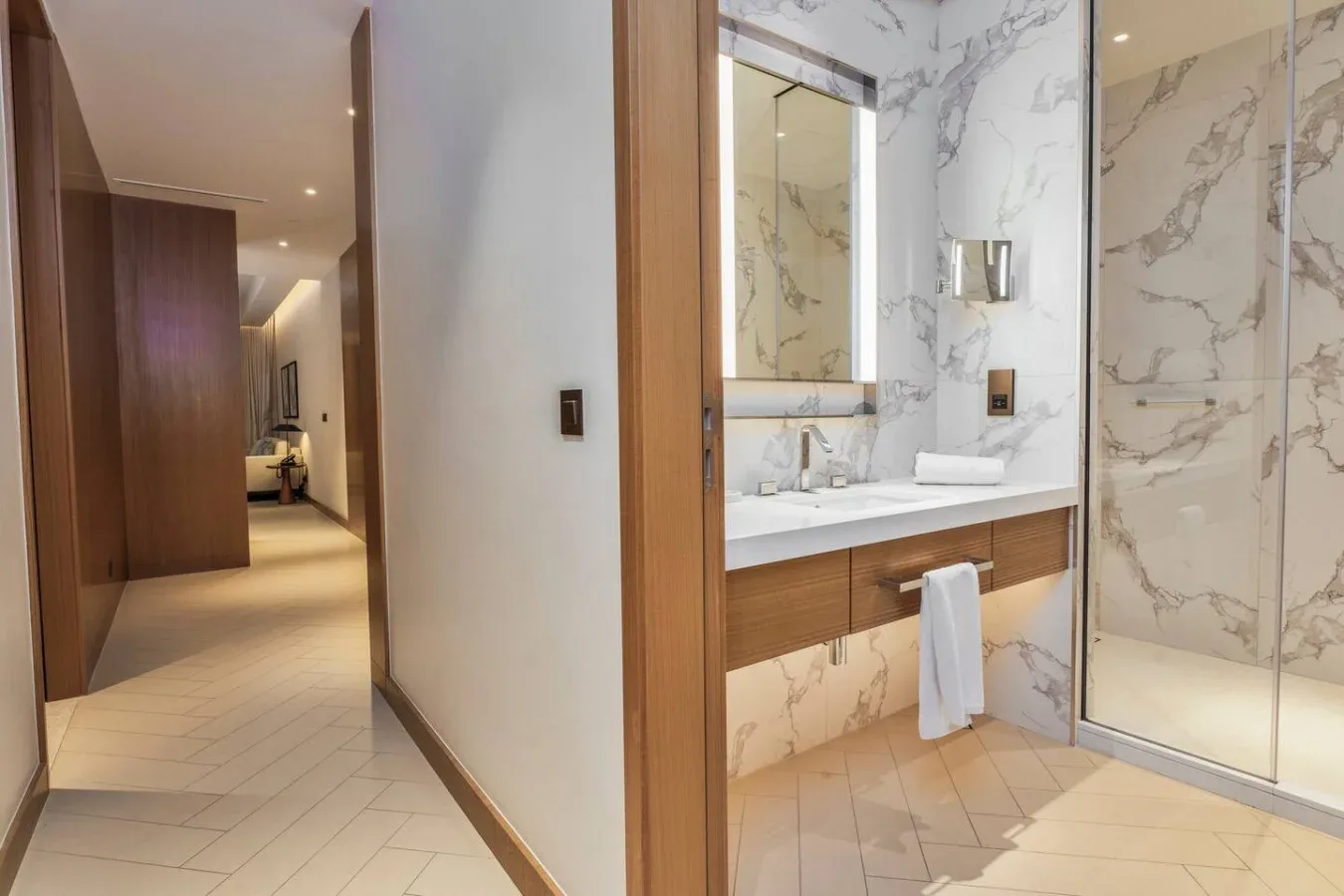 A bathroom with a long vanity and a glass shower enclosure.