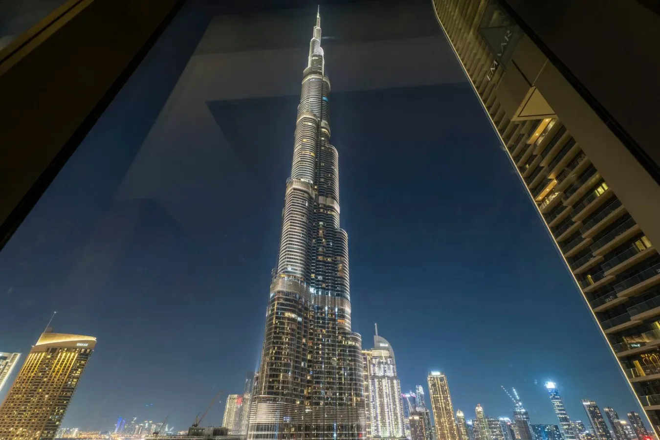 A nighttime city skyline features a tall illuminated skyscraper.