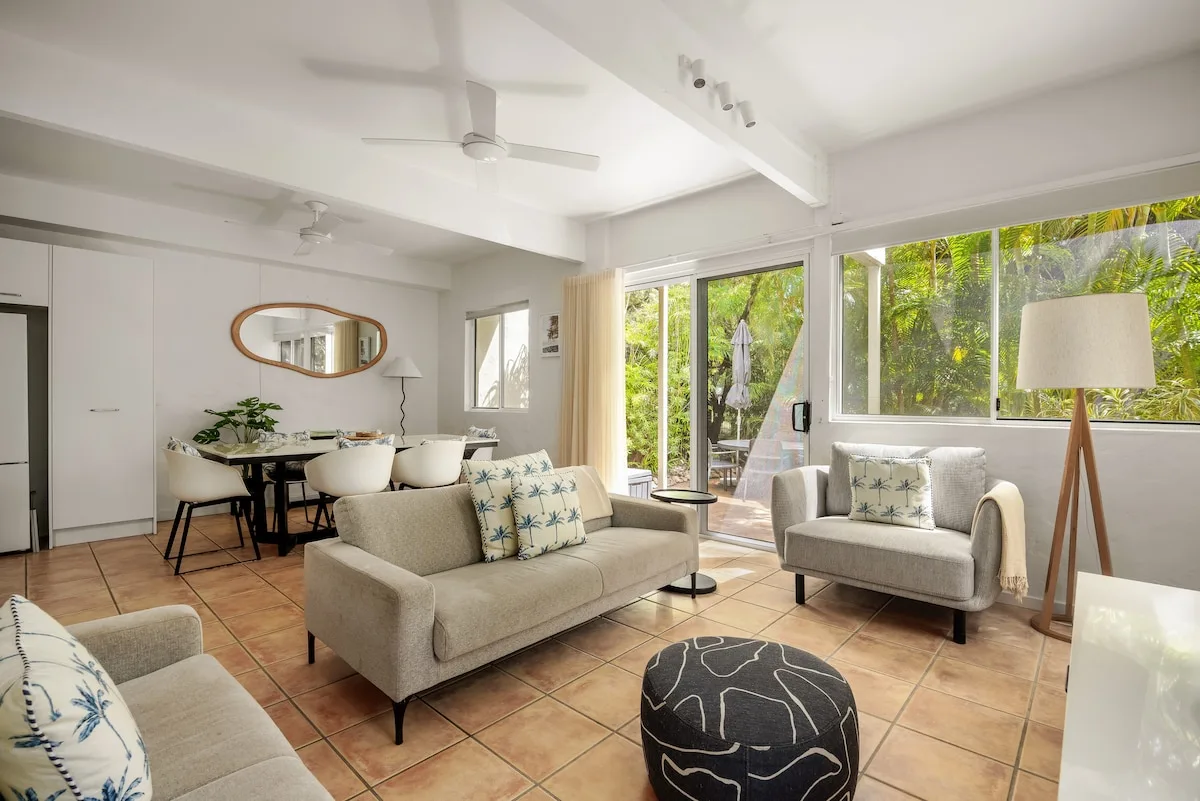 A bright living room with seating arranged around a small coffee table.