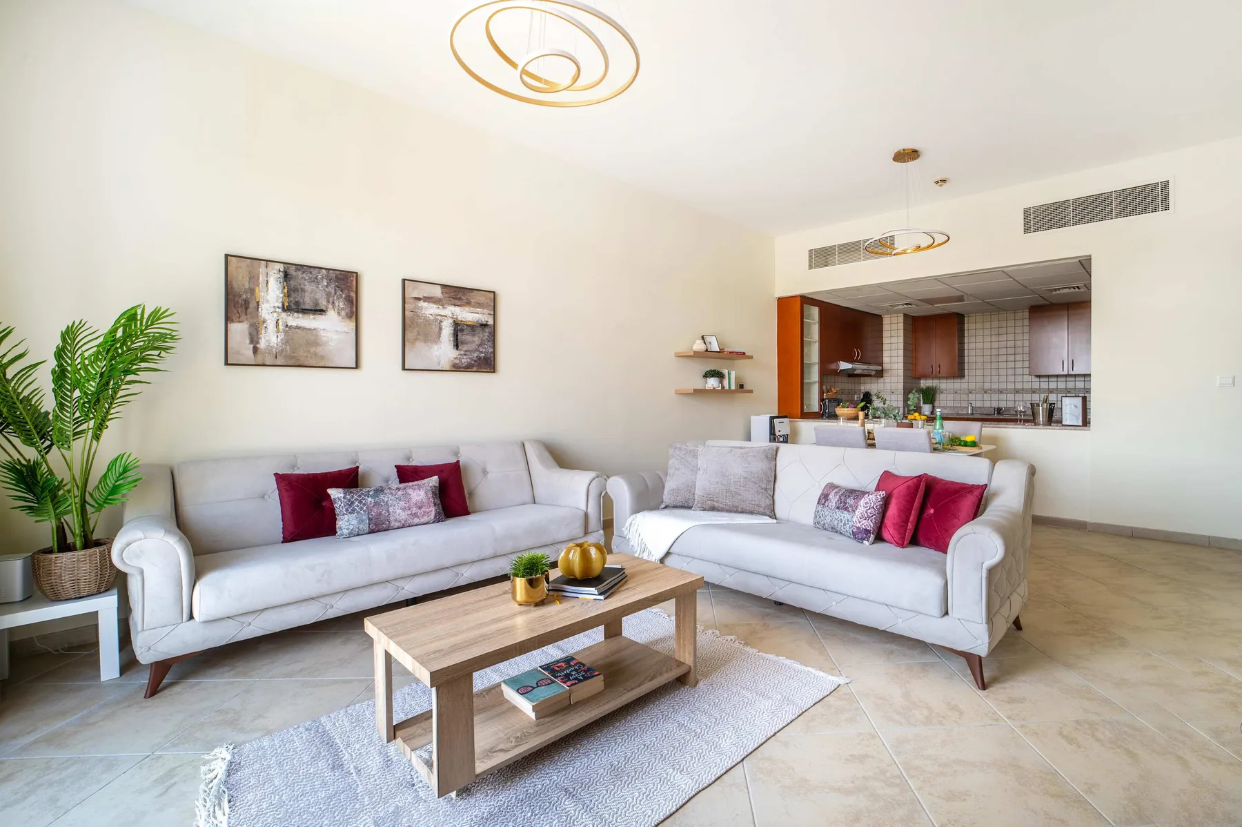 A bright living room with seating, a coffee table, and an open kitchen.