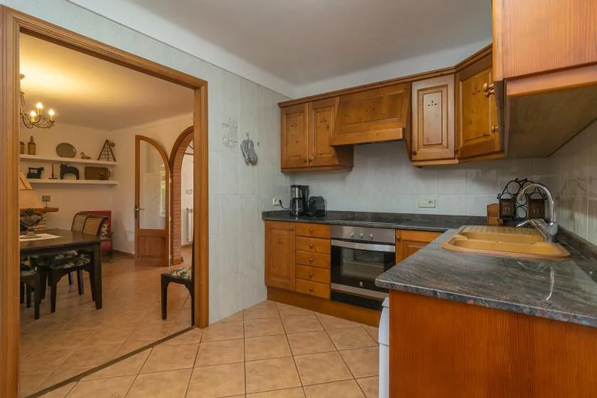 A kitchen with wooden cabinets, a countertop, and an oven.
