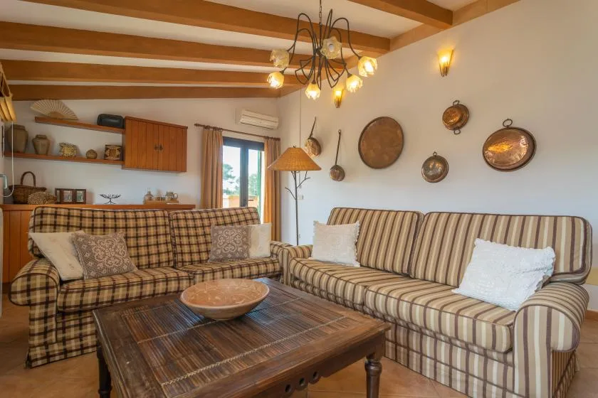 A living room with patterned seating and a wooden coffee table.