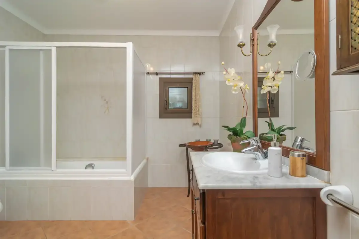 A bathroom with a bathtub, shower, and vanity.