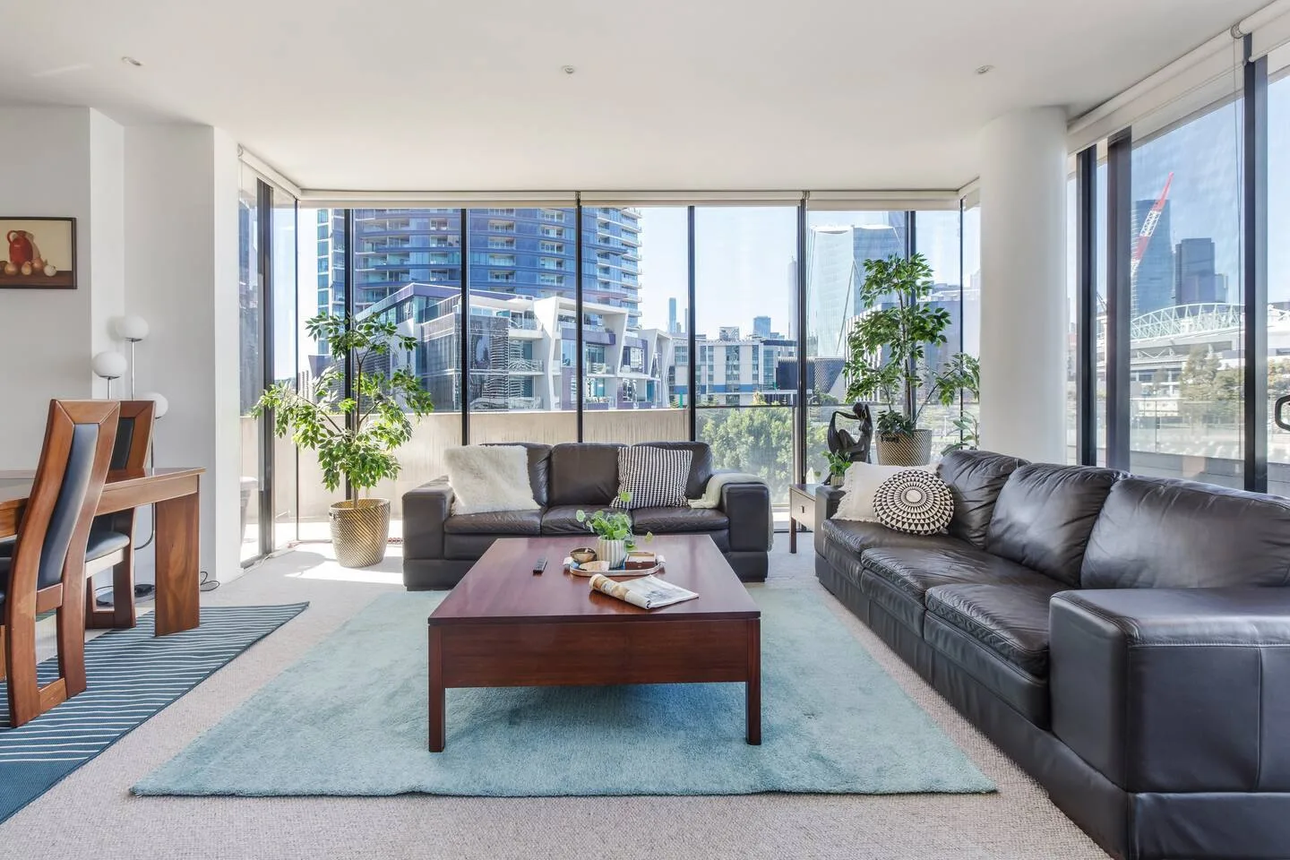 Una sala luminosa con asientos y grandes ventanales con vistas a edificios de la ciudad.