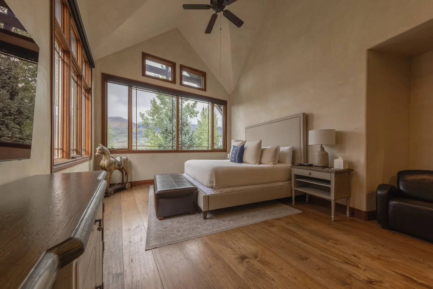 Una sala luminosa con una zona de estar junto a grandes ventanas.