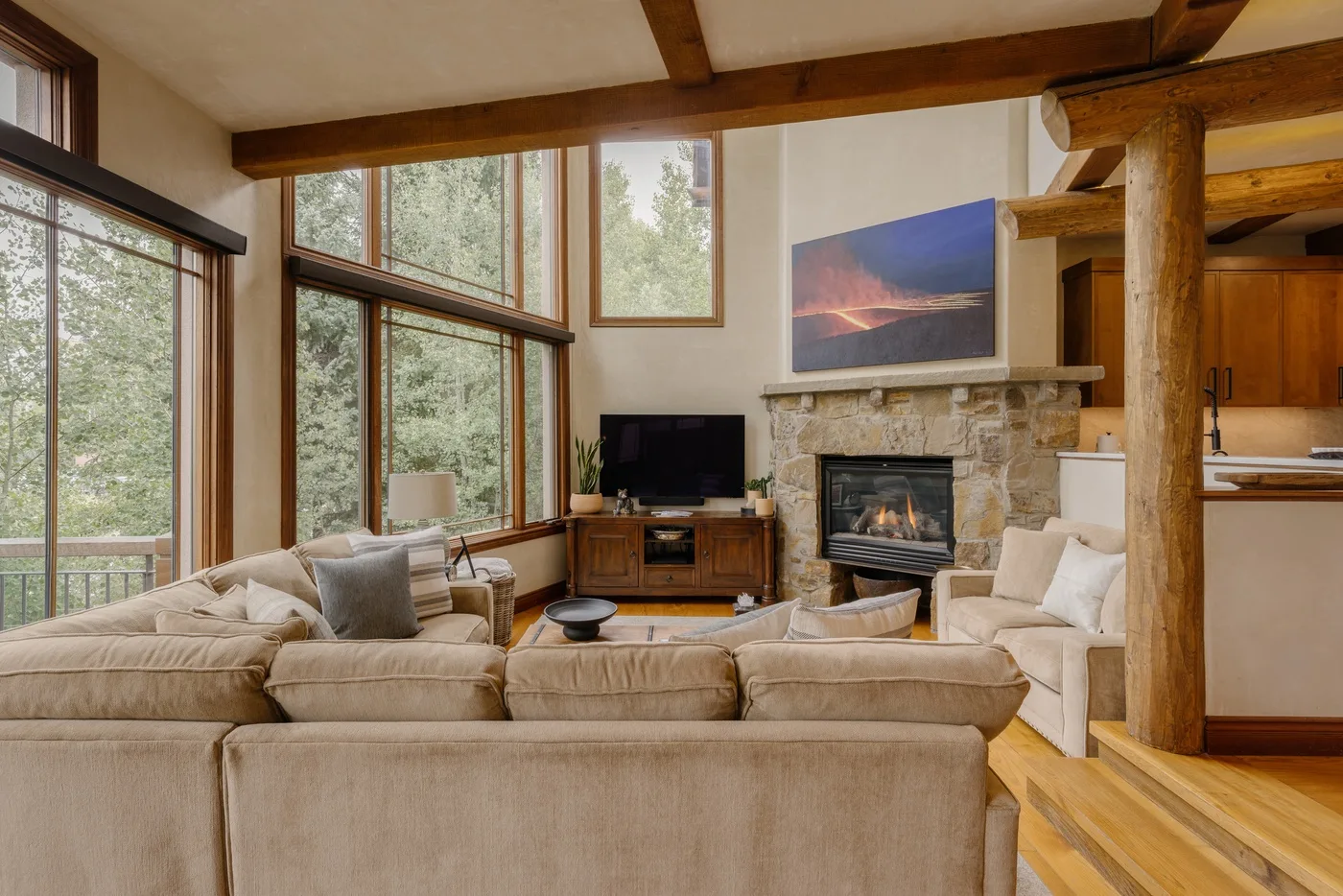 Una sala de estar con grandes ventanas, asientos cómodos y una chimenea de piedra.