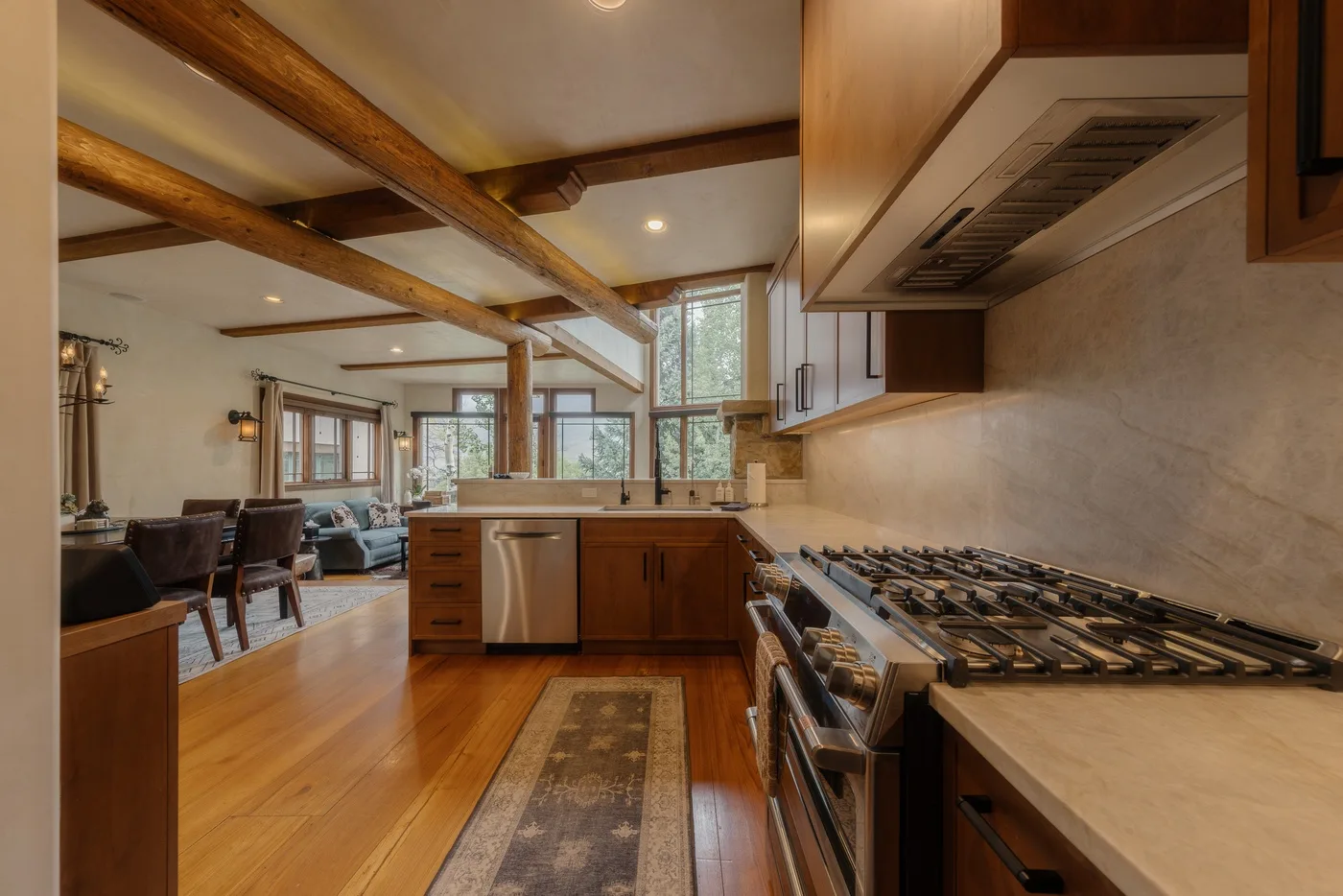 Una cocina amplia se abre a las zonas de comedor y estar, con muebles de madera y vigas expuestas.