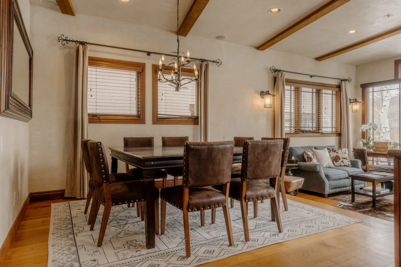 Comedor con mesa y sillas junto a una zona de estar con sofá.