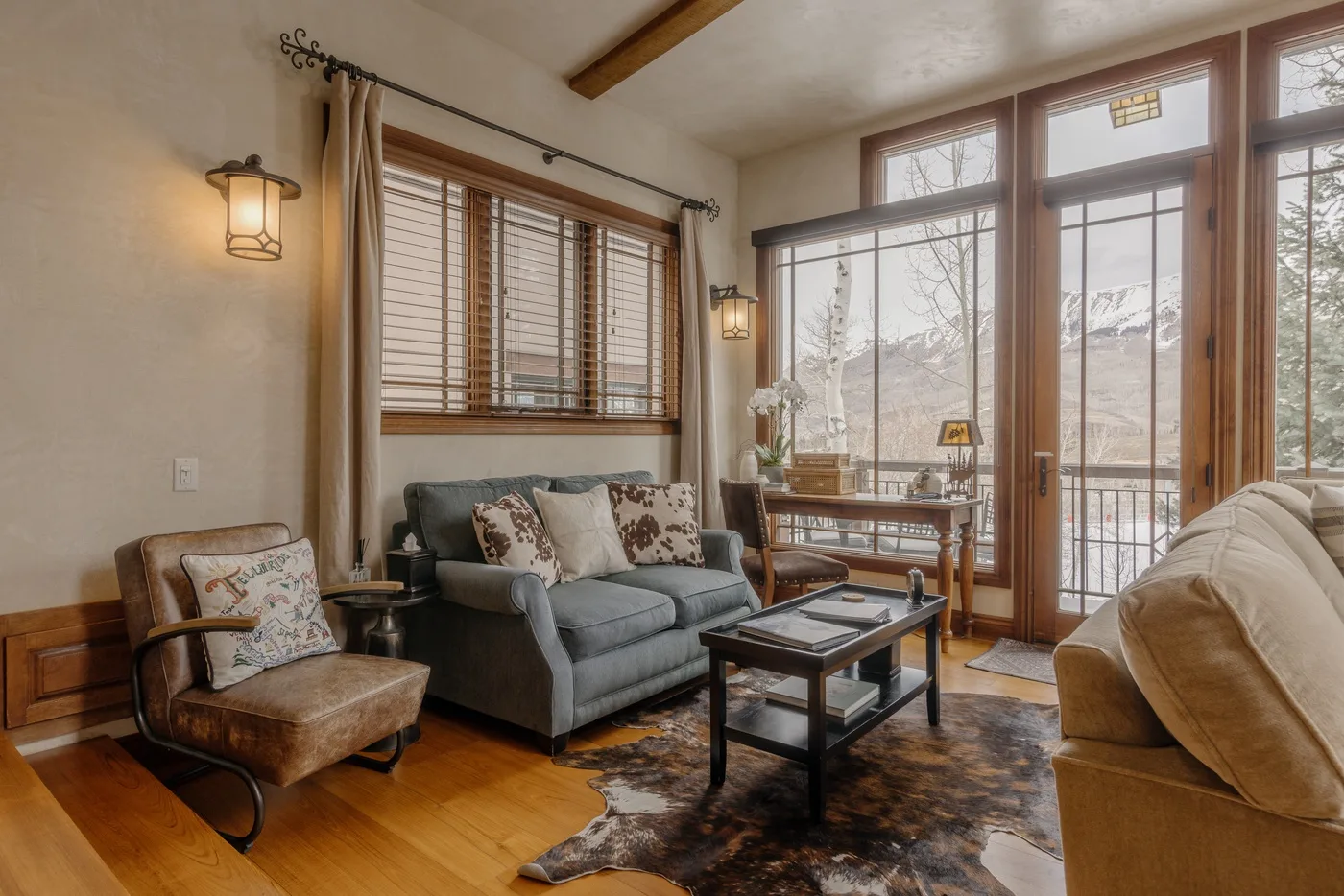 Una sala luminosa con asientos, una mesa de centro y grandes ventanas.