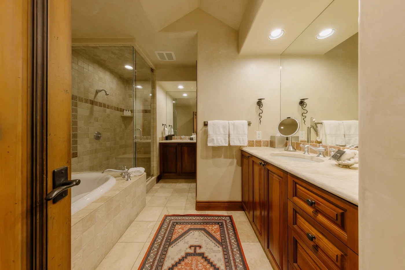 Un baño con una ducha de vidrio y un tocador largo.