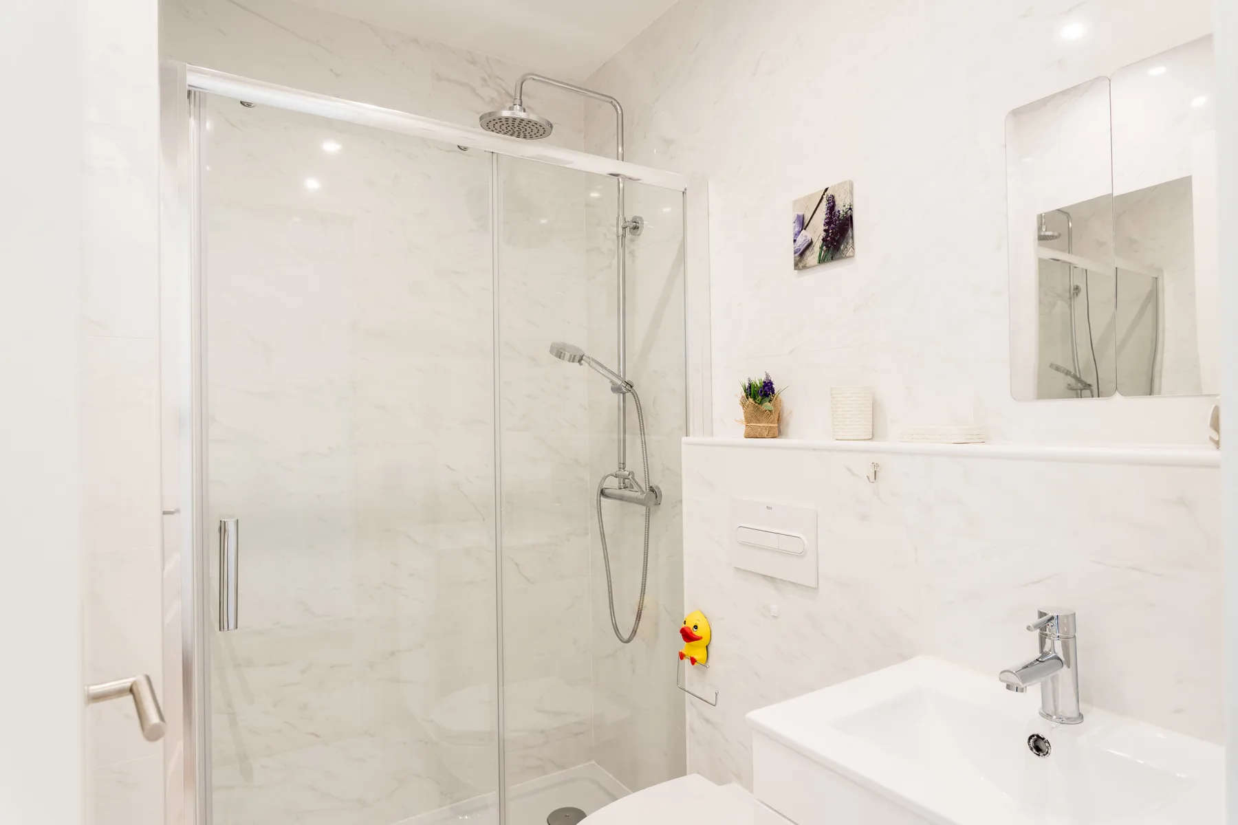 A bright bathroom with a glass shower and sink.