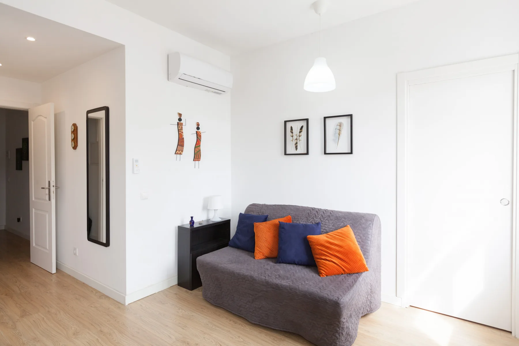 A bright living room with a gray sofa and colorful cushions.