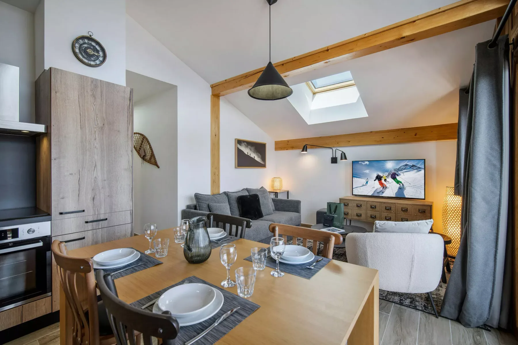 Un comedor y sala de estar diáfanos con una mesa puesta y asientos.