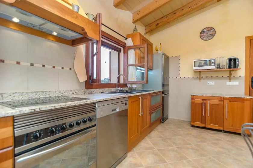 A kitchen with wooden cabinets, a tiled floor, and a countertop beneath the window.