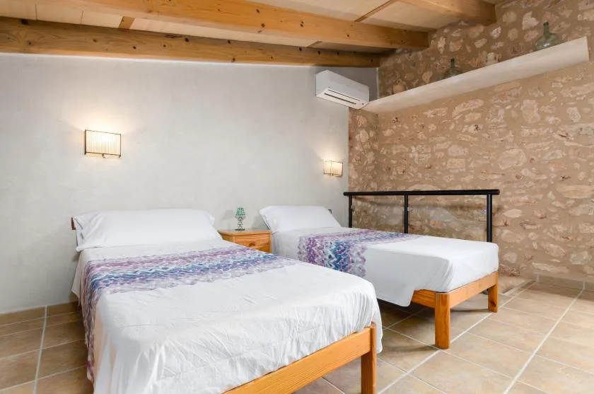 A bedroom with two beds and a small bedside table.