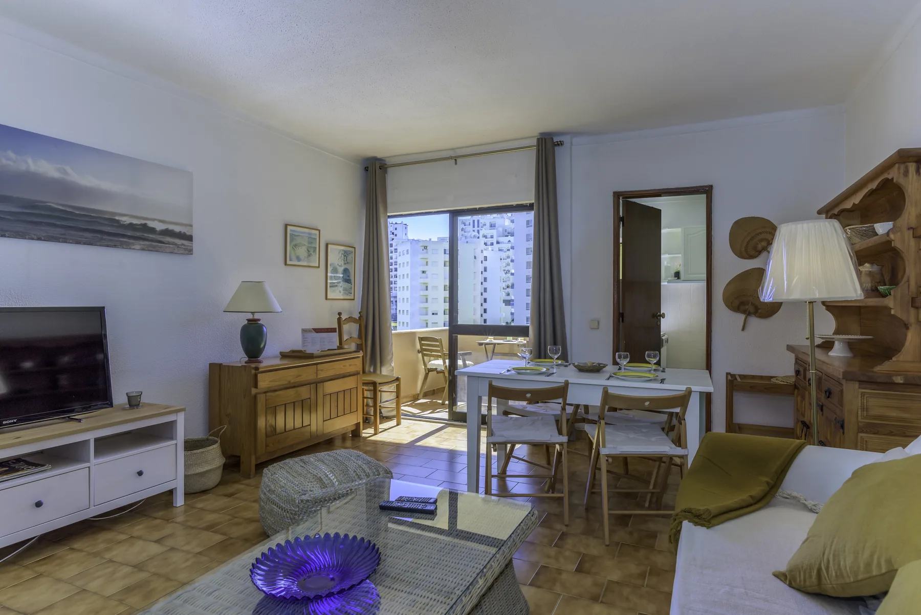 Living and dining area with a table and seating beside a large window.