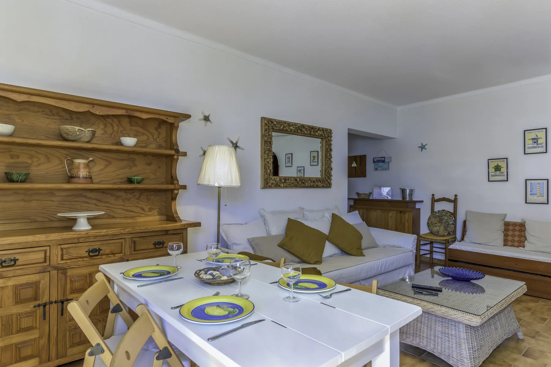 A living and dining area with a table, seating, and wooden shelving.