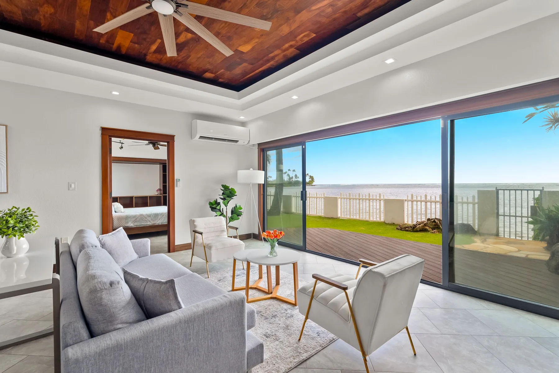 A bright living room opens onto a patio through large sliding glass doors.