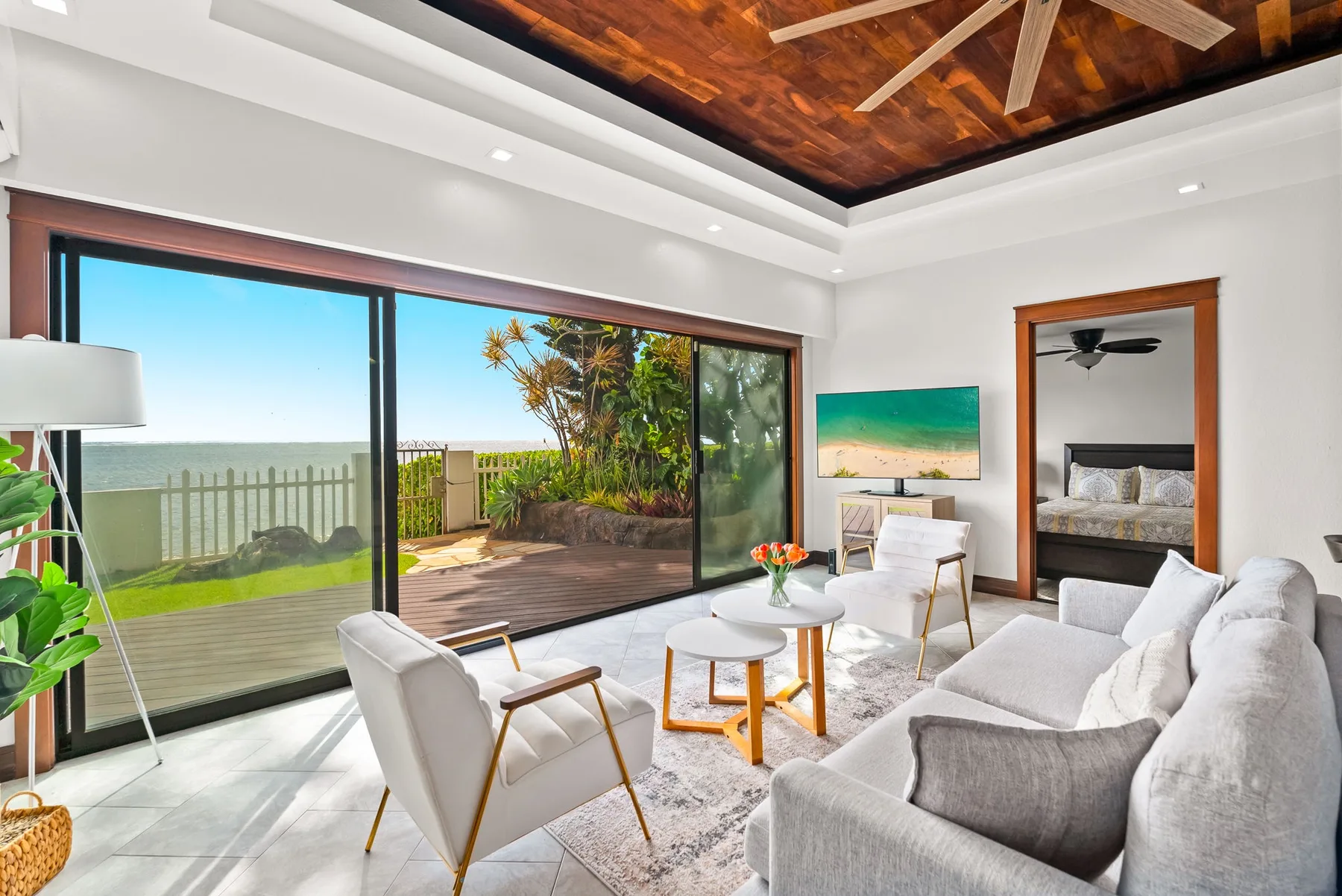 A bright living room opens onto a patio through large sliding glass doors.