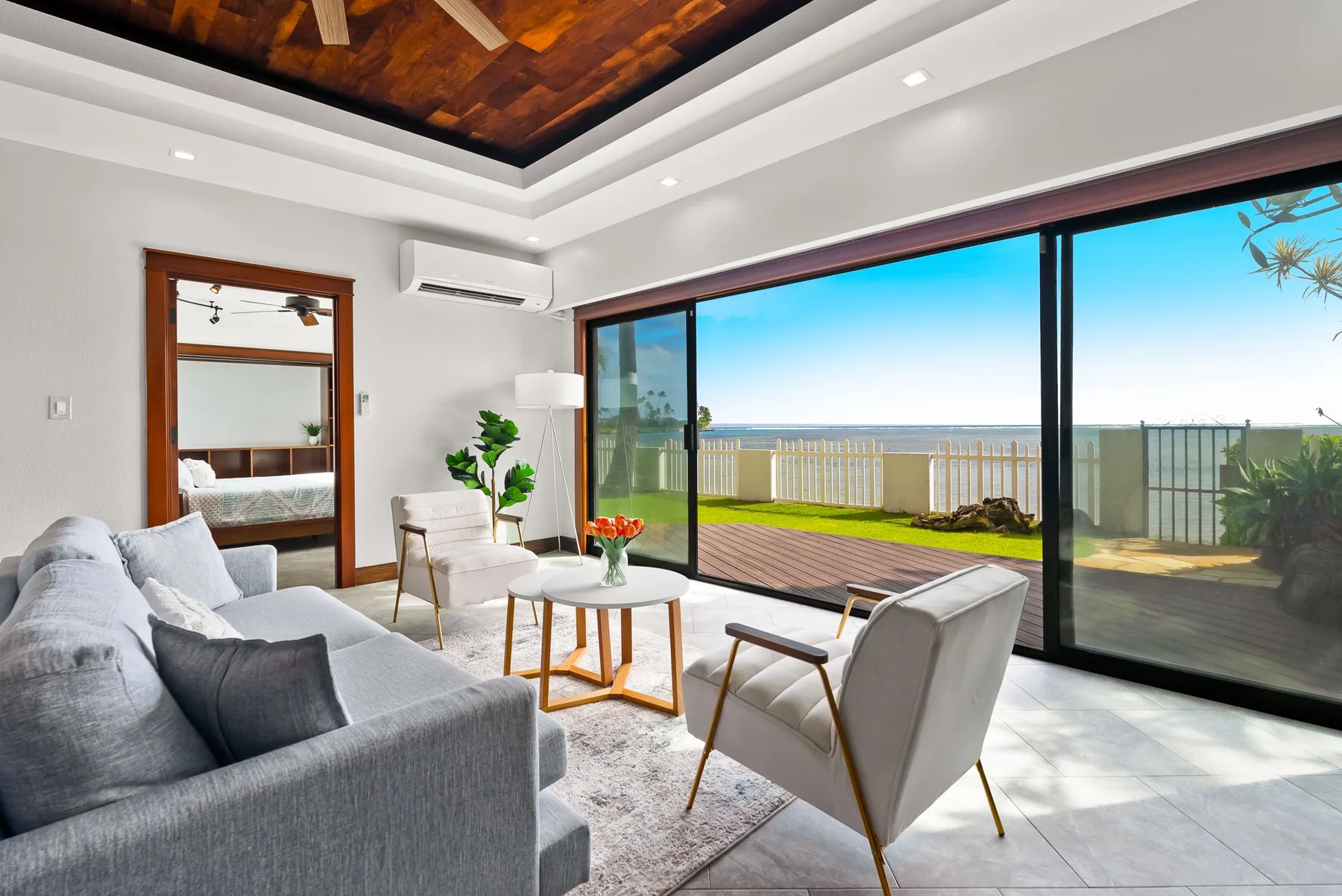 A bright living room opens onto a patio through large sliding glass doors.