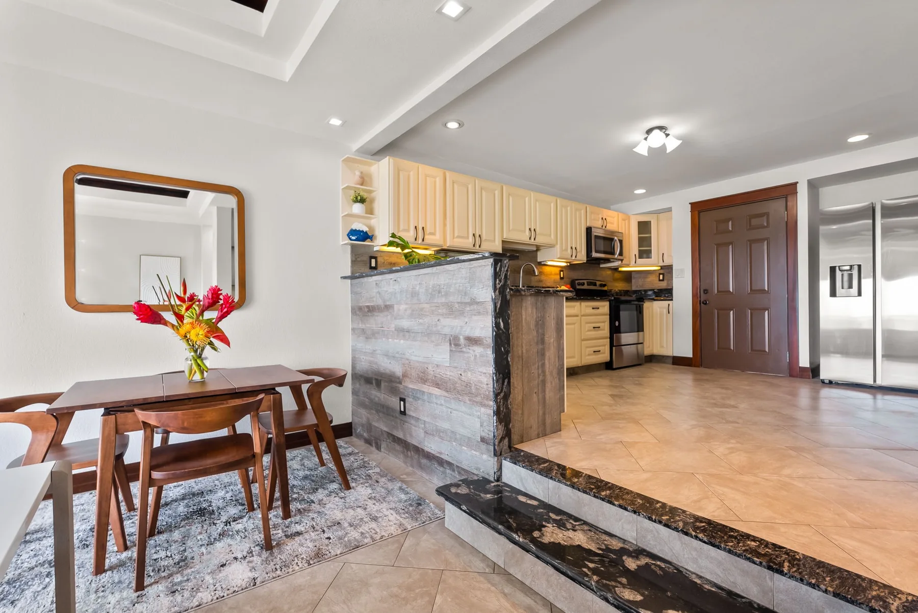 An open-plan kitchen and dining area with light wood cabinetry and a dining table.