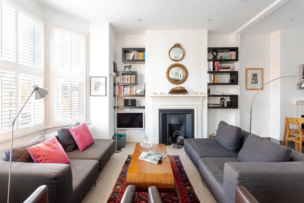 A bright living room with seating arranged around a wooden coffee table.