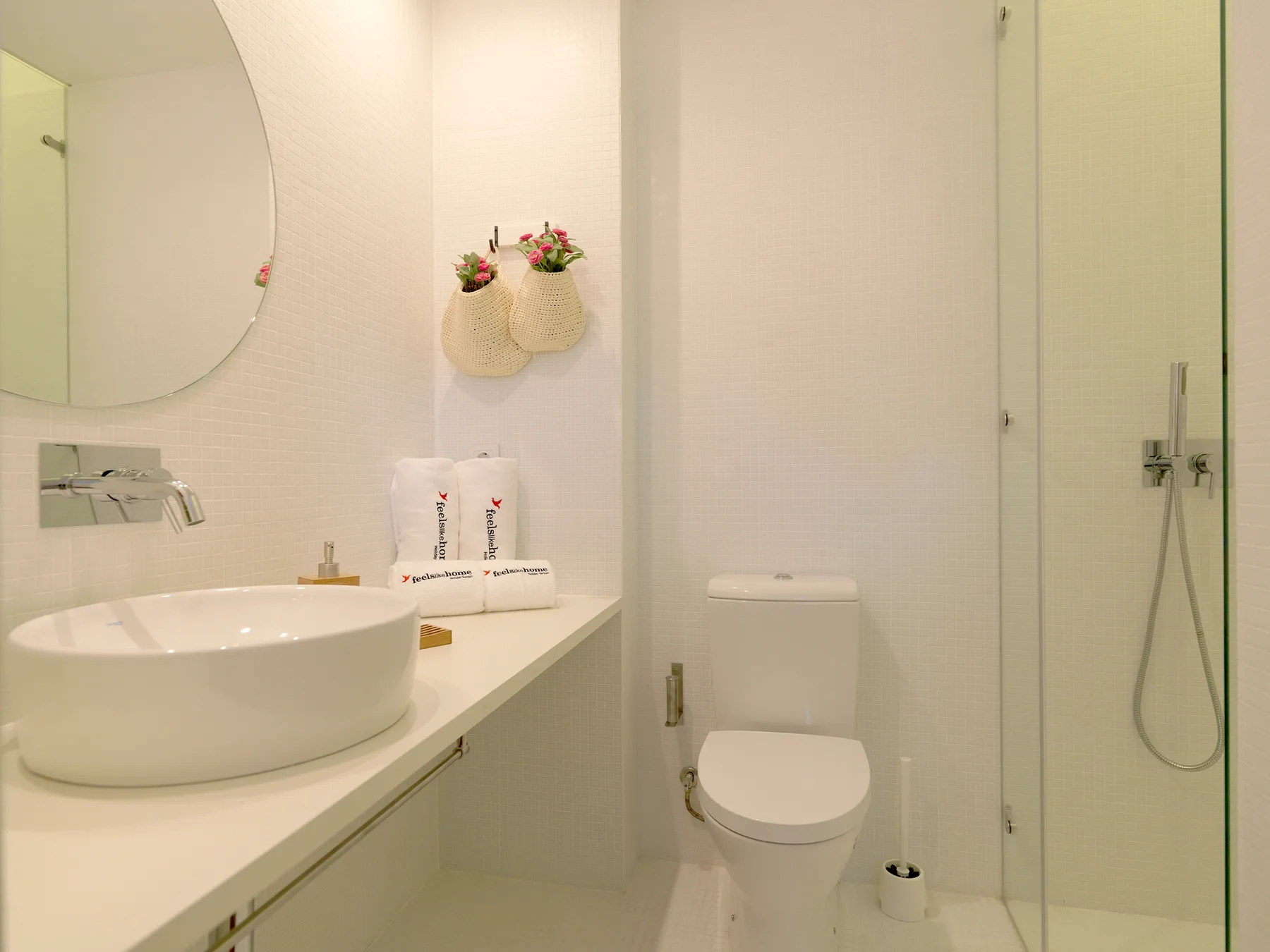 A bright bathroom with a sink, toilet, and glass shower.