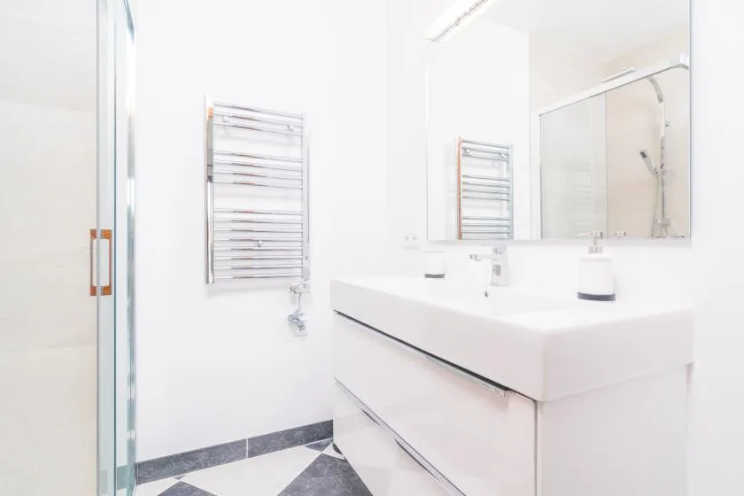 A bright bathroom with a glass shower and a wide sink vanity.