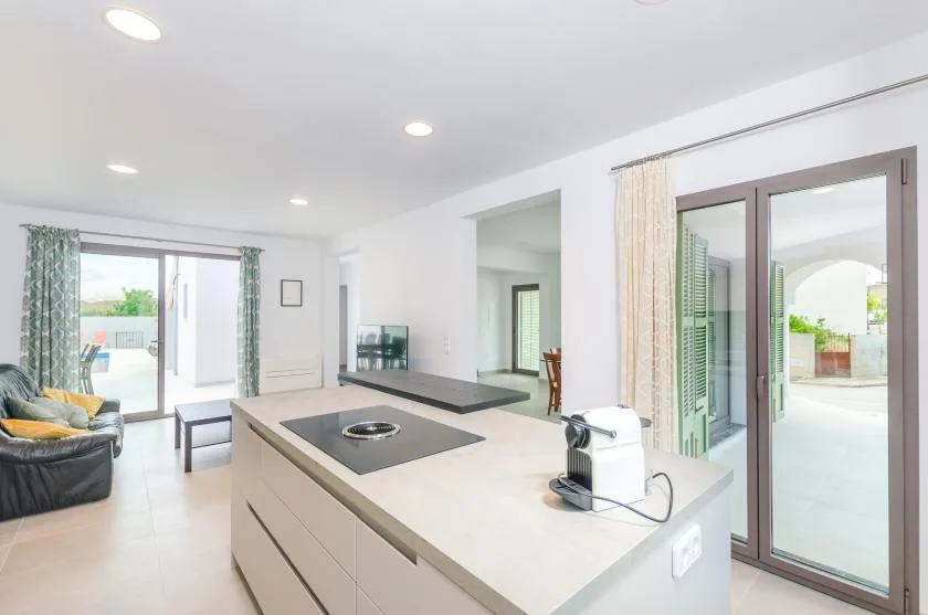 A bright open-plan living area with a kitchen island and sliding glass doors.