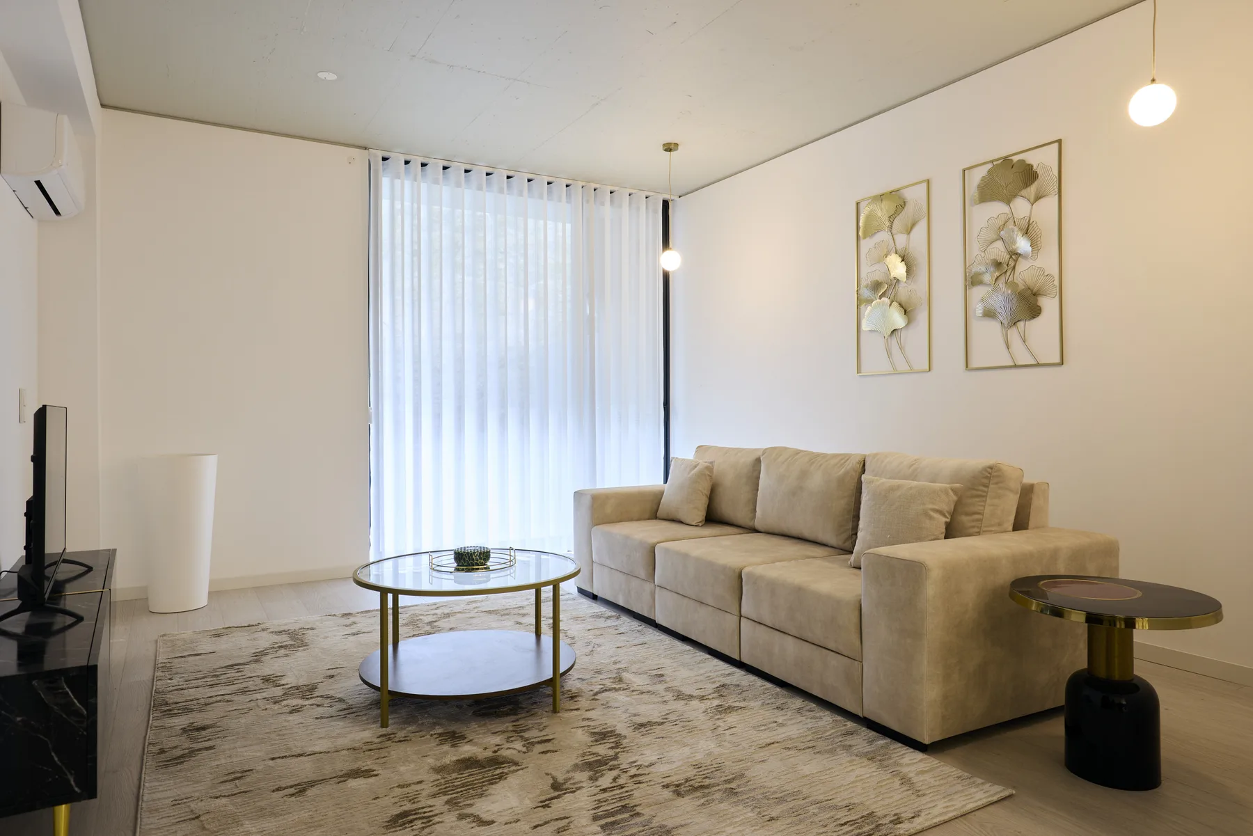 Living room with beige seating, a coffee table, and tall curtains.