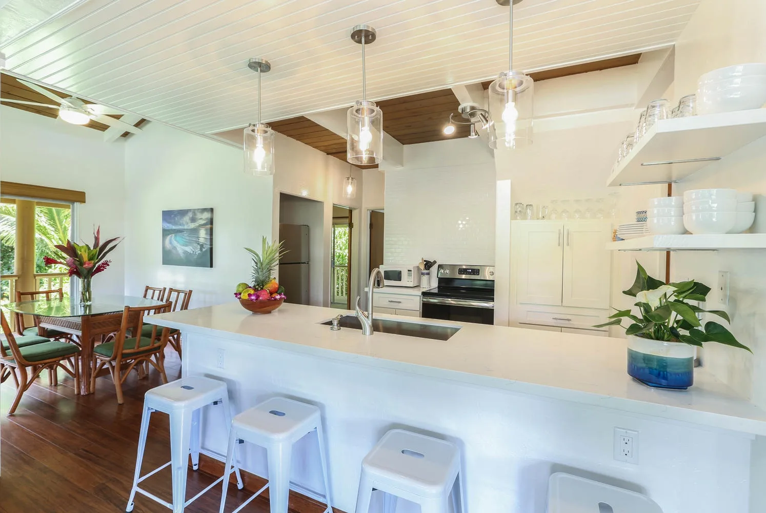 A bright kitchen with a long island and dining area beside the windows.