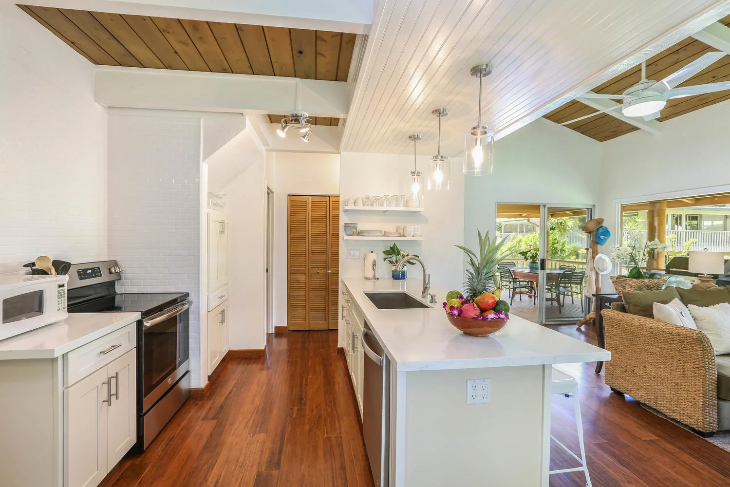 An open kitchen and living area with a central island and wood flooring.
