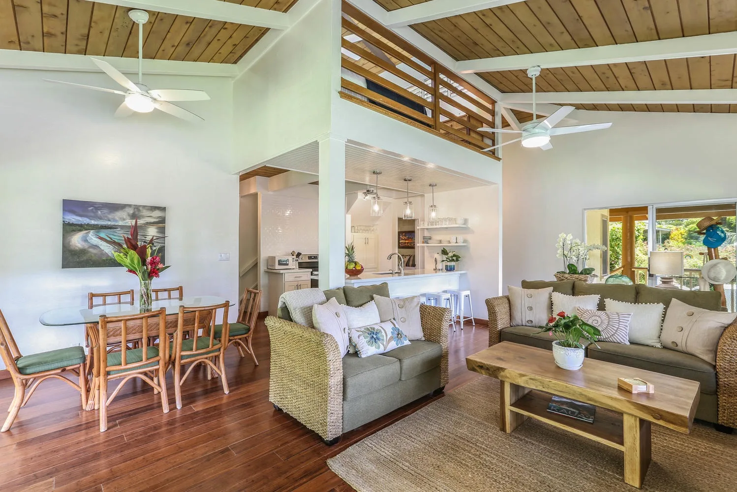 An open living and dining area with seating, a dining table, and a wood-paneled ceiling.
