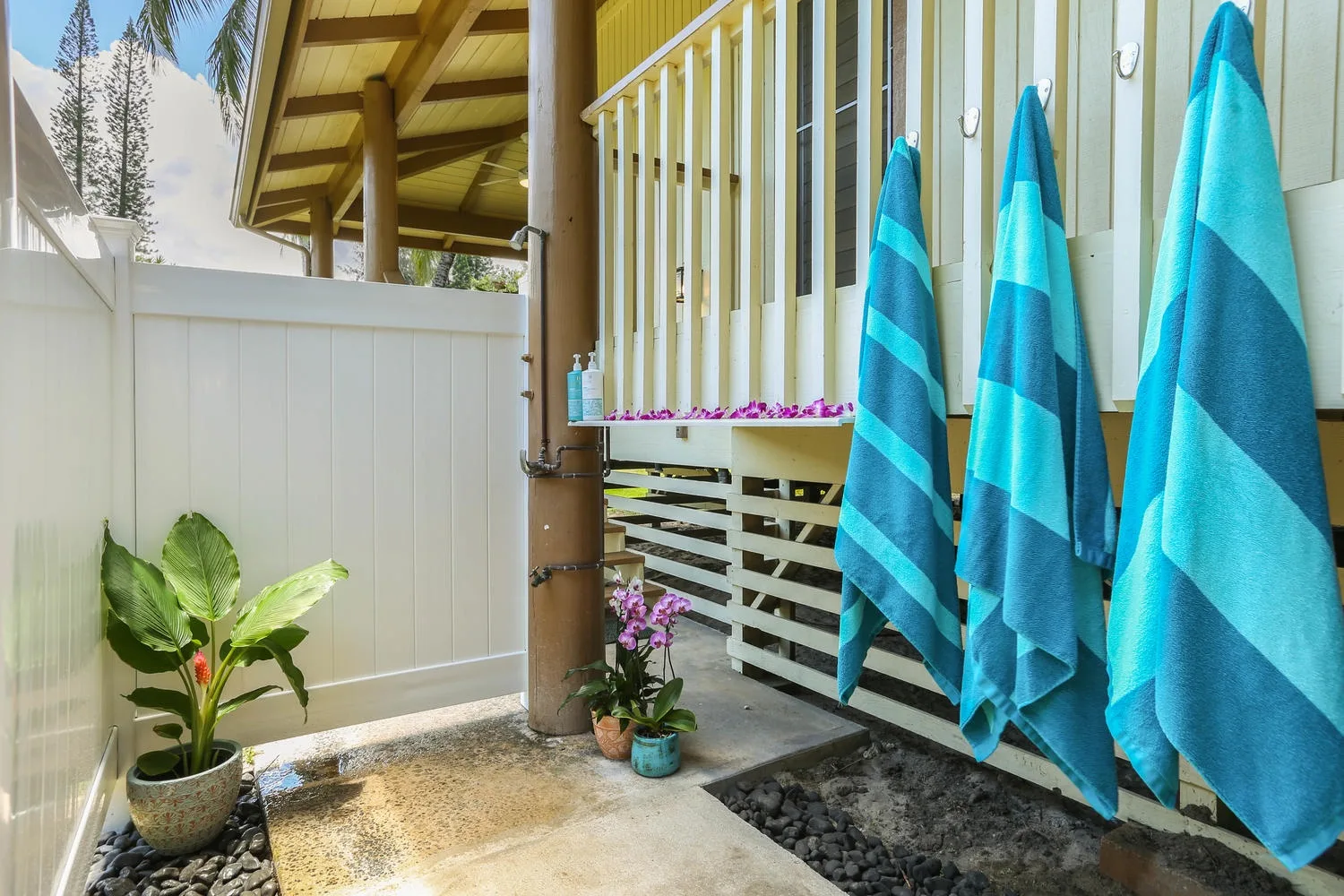 An outdoor patio beside a building, with blue towels hanging on a railing.