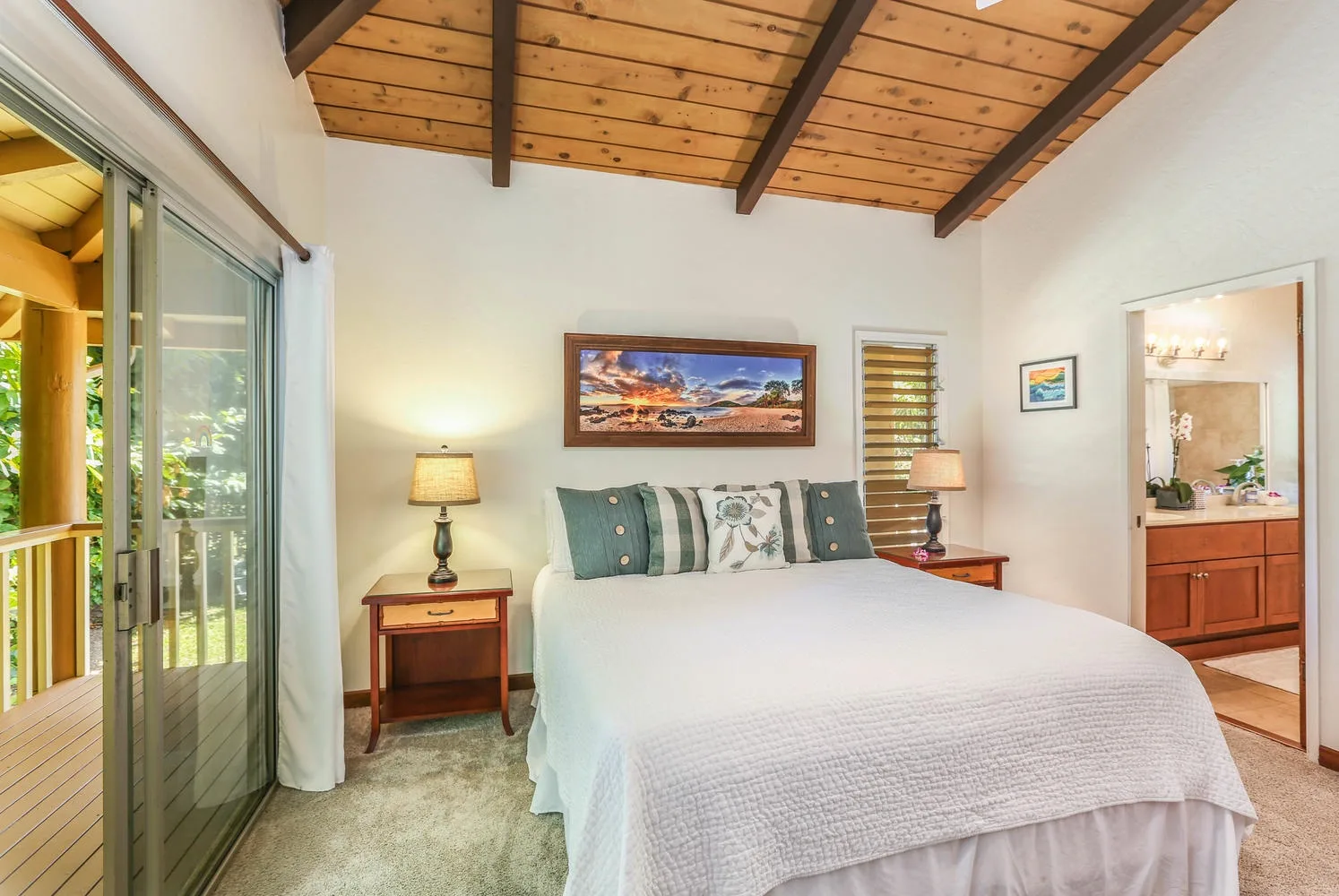 A bedroom with a bed beneath a wood-paneled ceiling and a sliding glass door.