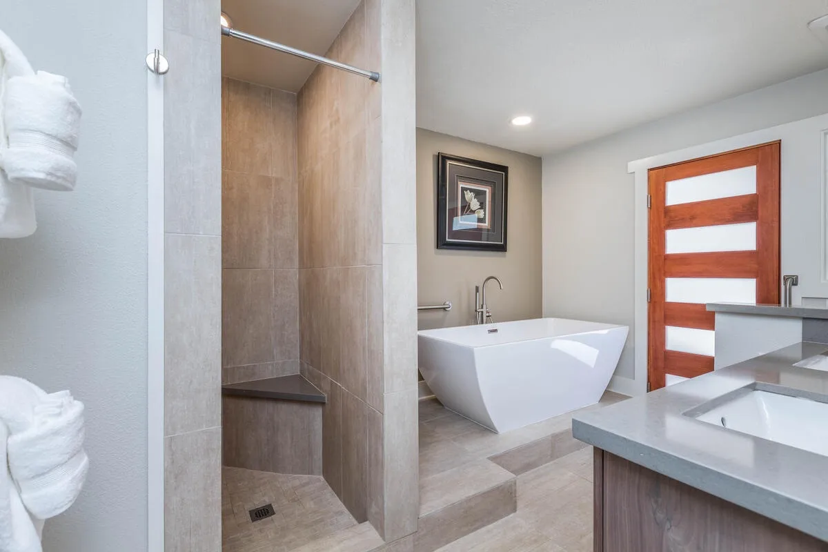 A modern bathroom with a walk-in shower, freestanding bathtub, and vanity.