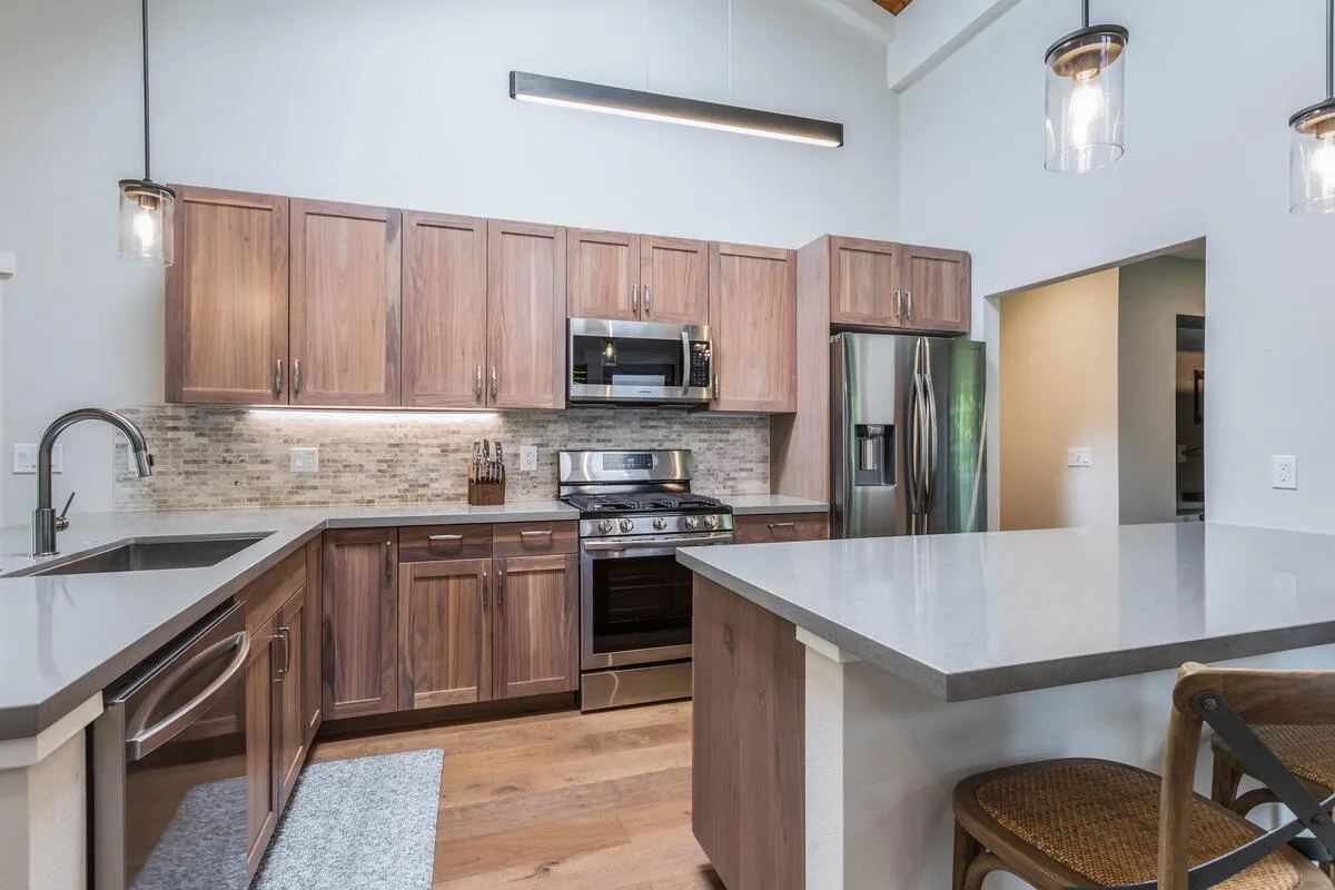 Una cocina moderna con gabinetes de madera, electrodomésticos de acero inoxidable y una isla grande.