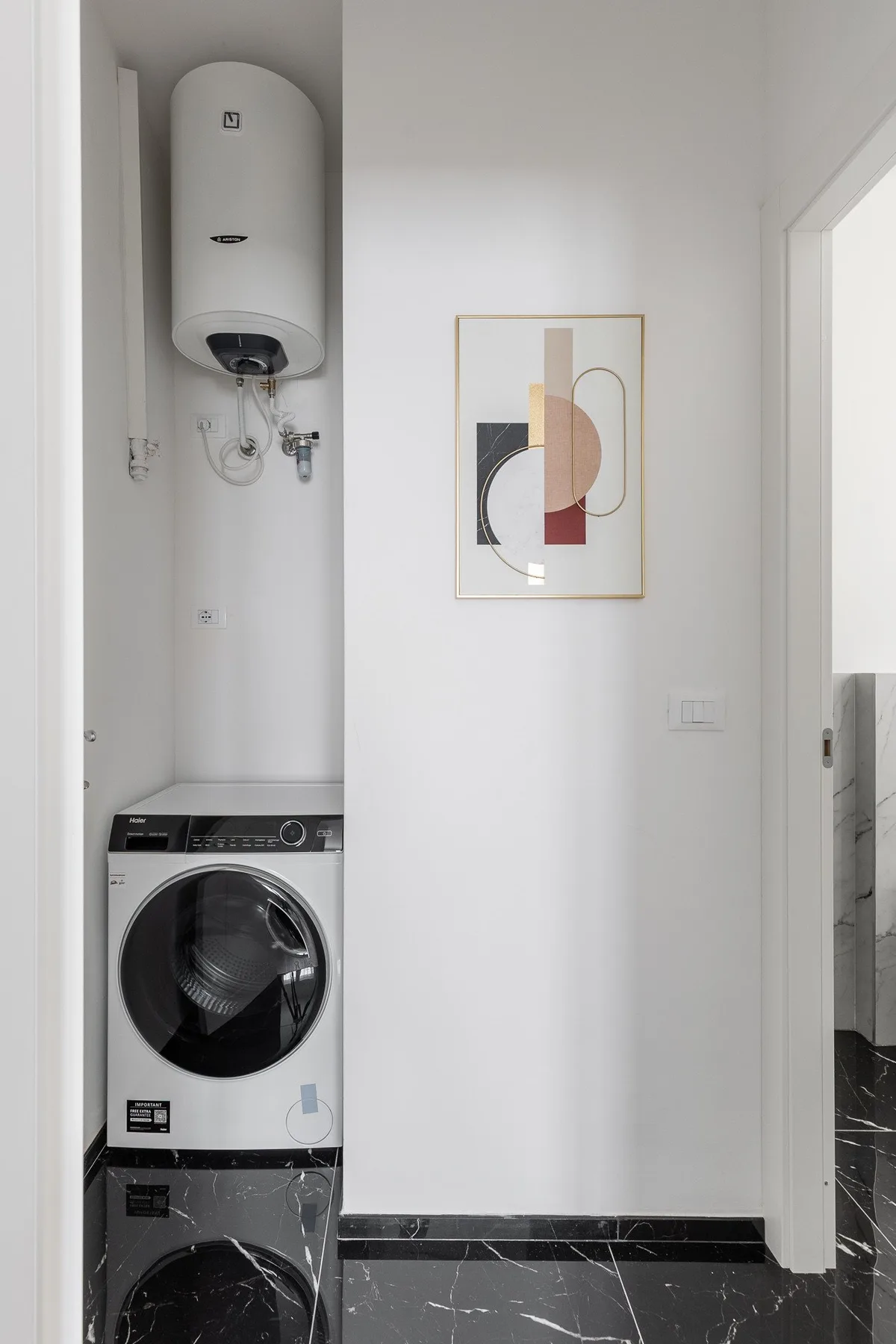 A laundry area with a washing machine beneath a wall-mounted water heater.