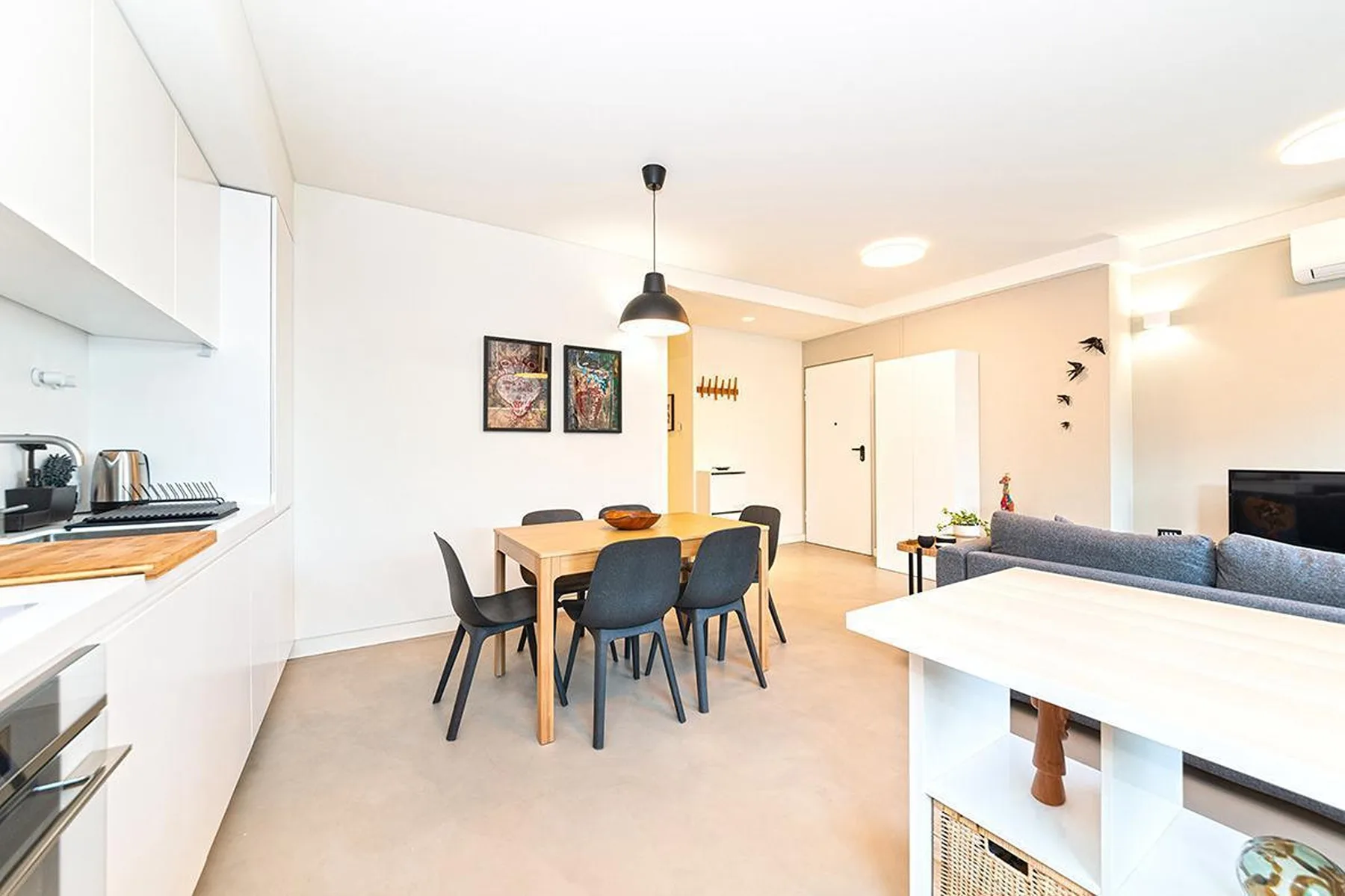 Una cocina y comedor de planta abierta con una mesa junto a la sala de estar.